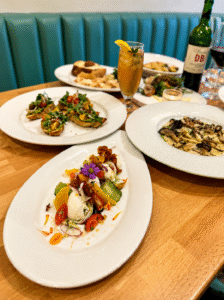 A bright, airy Mother's Day dining setup at The Wild Artichoke with fresh floral centerpieces, perfect for an elevated "indoor picnic" feel.